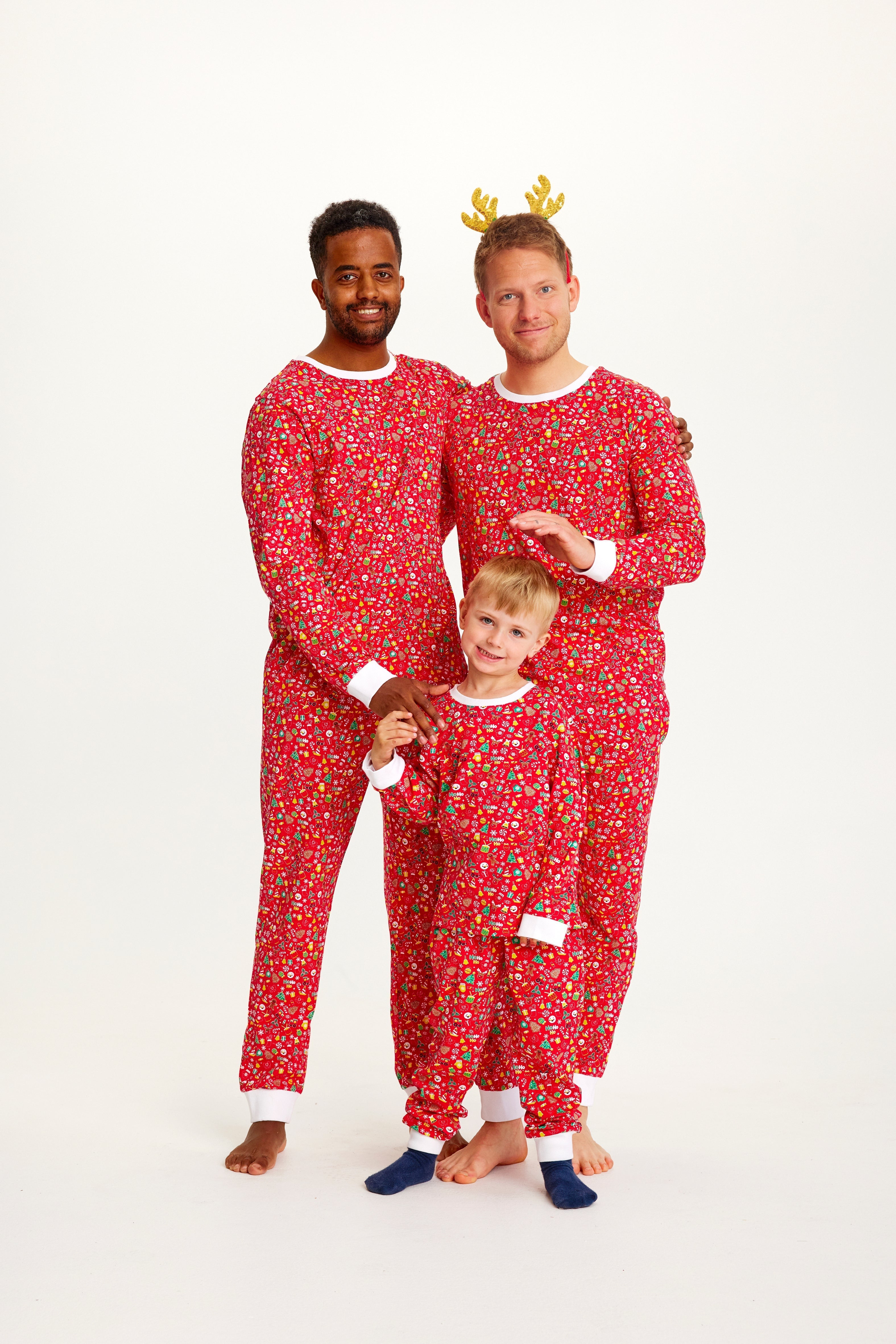 En familj i ljusröd julpyjamas med julsaker.